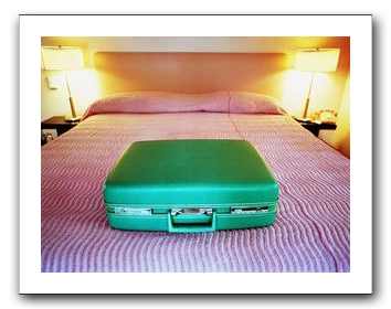 suitcase on a bed, looking lonely