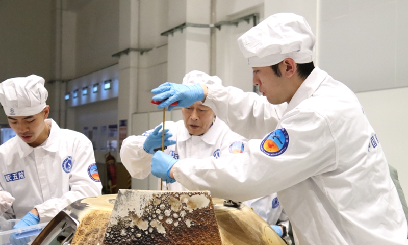 Scientists extract the samples from the Chang'e 5 spacecraft.
