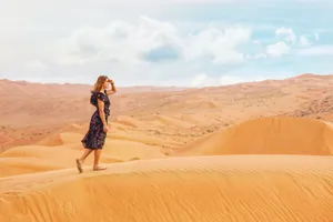 A woman standing on a sand dune