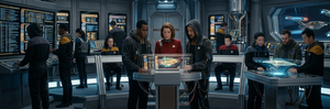 Security engineers on the deck of a Star Trek ship examining data on multiple screens.