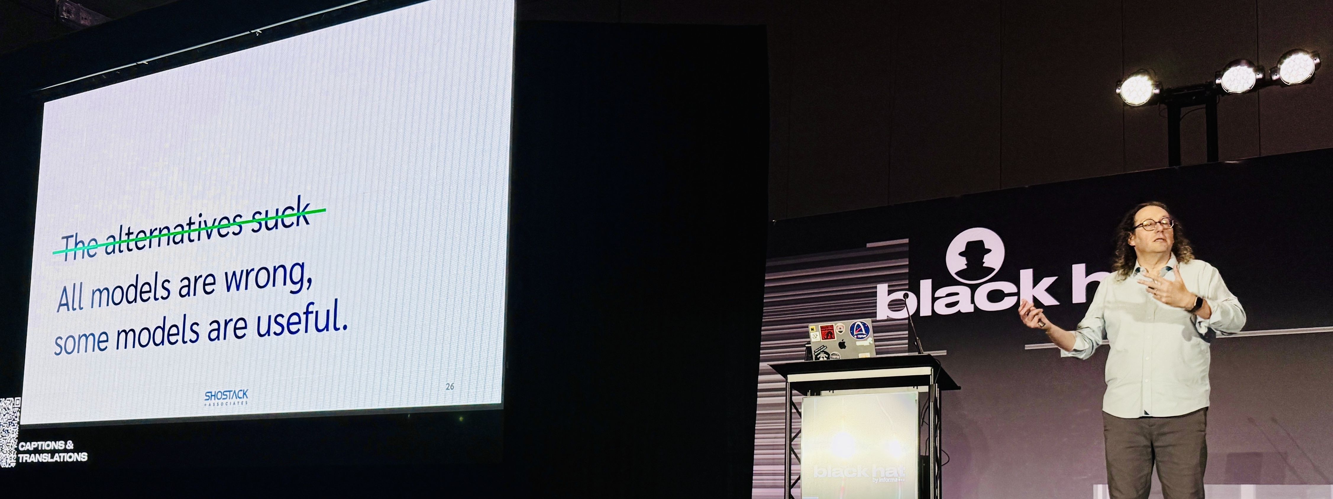 Adam on stage at Black Hat 2026. The slide reads: All models are wrong, some models are useful