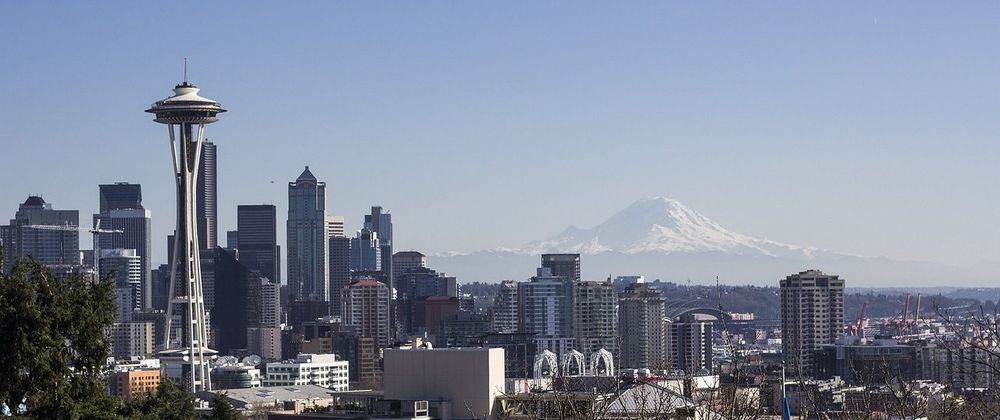 View of Seattle, including the Space Needle to the left and Mount Rainier in the distance.